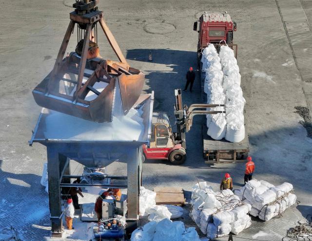Fertiliser is unloaded from a ship at the port in Lianyungang, in China’s eastern Jiangsu province on April 7, 2026. (Photo by CN-STR / AFP) / China OUT