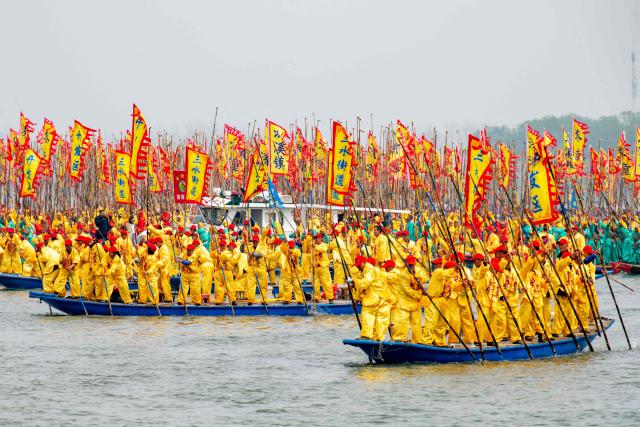 People take part in the Taizhou Jiangyan Qintong Boat Festival on Qinhu lake in Taizhou, in China’s eastern Jiangsu province on April 6, 2026. Thousands took part in the annual festival, which occurs during the Qingming, or Tomb Sweeping festival holiday. (Photo by CN-STR / AFP) / China OUT