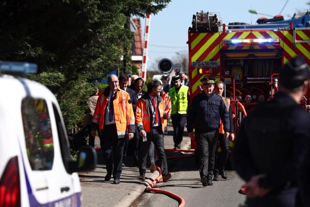Prefect of the Herault department François-Xavier Lauch (C) and President of French railway company SNCF Jean Castex (L) walk past firefighters vehicles as they arrive after a collision of a TGV train at a level crossing with a lorry between Bethune and Lens, in Bully-les-Mines, in the Pas-de-Calais region, northern France on April 7, 2026. The driver of the TGV train died and 27 people were injured in the accident, AFP has learnt from the prefecture and the SNCF. (Photo by Sameer AL-DOUMY / AFP)