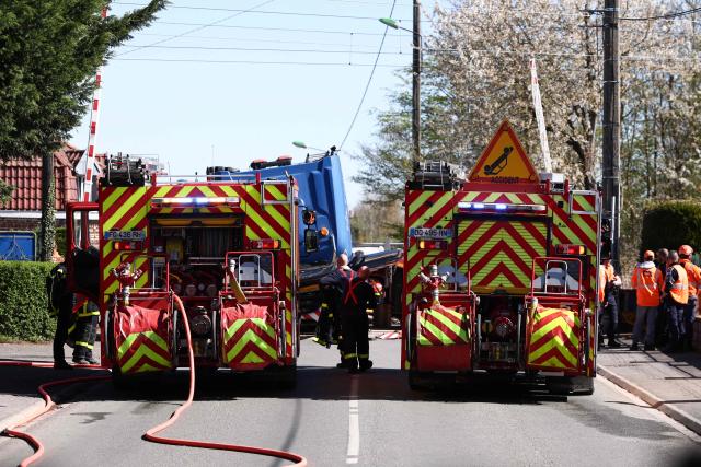 Firefighters vehicles are parked near the weckrage of a lorry after its collision with a TGV train at a level crossing between Bethune and Lens, in Bully-les-Mines, in the Pas-de-Calais region, northern France on April 7, 2026. The driver of the TGV train died and 27 people were injured in the accident, AFP has learnt from the prefecture and the SNCF. (Photo by Sameer AL-DOUMY / AFP)
