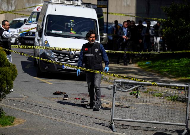Police officials gather near bloodstained clothing outside The Israeli Consulate in Istanbul on April 7, 2026, following a shootout between gunmen and police. One gunman was killed and two others were wounded in a shootout with police outside the Israeli consulate in Istanbul, the local governor said, adding two officers were lightly wounded (Photo by Yasin AKGUL / AFP)