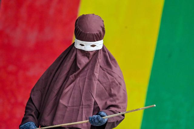 A member of Aceh's Sharia police wields a rattan stick during a public flogging in Banda Aceh on April 7, 2026. A couple was publicly flogged in Indonesia's staunchly Islamic Aceh province on April 7 for having sex outside of marriage, an AFP reporter witnessed, in the country's only region to apply a version of Sharia law. Sexual relations between unmarried people are outlawed in Aceh. (Photo by CHAIDEER MAHYUDDIN / AFP)