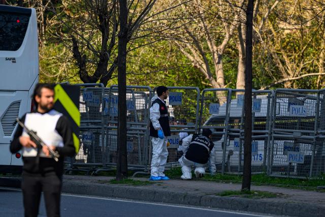 Police forensic officers inspect a scene near The Israeli Consulate in Istanbul on April 7, 2026, following a shootout between gunmen and police. A gunman who was killed in a shootout on April 7, 2026, with police outside Israel's consulate building in Istanbul's business district was affiliated with "a terror group," officials said. (Photo by Yasin AKGUL / AFP)