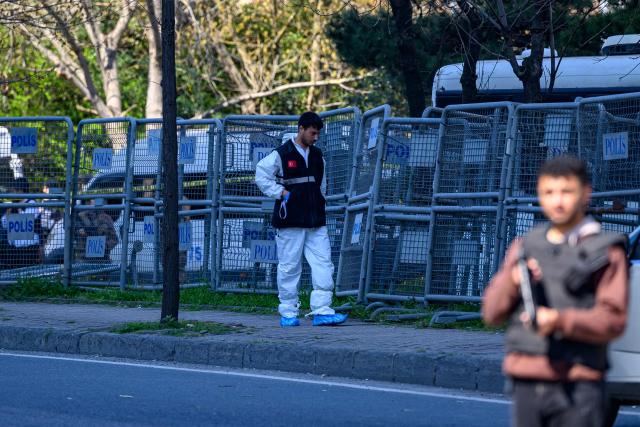 A police forensic officer inspects a scene near The Israeli Consulate in Istanbul on April 7, 2026, following a shootout between gunmen and police. A gunman who was killed in a shootout on April 7, 2026, with police outside Israel's consulate building in Istanbul's business district was affiliated with "a terror group," officials said. (Photo by Yasin AKGUL / AFP)