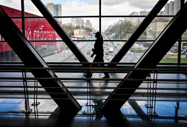 A woman walks along a pedestrian overpass in western Moscow on April 7, 2026. (Photo by Alexander NEMENOV / AFP)