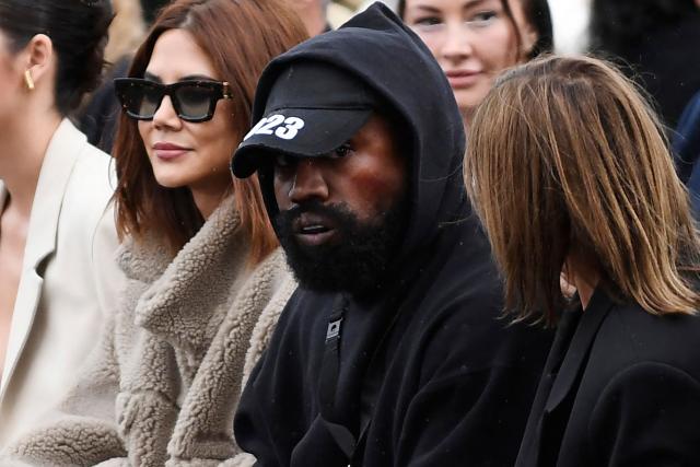 (FILES) US rapper Kanye West (C) attends the Givenchy Spring-Summer 2023 fashion show during the Paris Womenswear Fashion Week in Paris on October 2, 2022. The UK government on April 7, 2026 blocked US rapper Kanye West from visiting to headline a music festival amid a backlash over his past antisemitic outbursts, according to the BBC. (Photo by JULIEN DE ROSA / AFP)