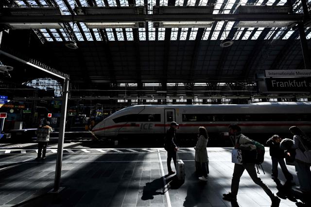 Passengers walk on a platform past an ICE high speed train at the main railway station in Frankfurt am Main, western Germany, on April 7, 2026. (Photo by Kirill KUDRYAVTSEV / AFP)