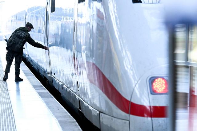 A passenger tries to enter an ICE high speed train of German railway operator Deutsche Bahn (DB) at the main railway station in Frankfurt am Main, western Germany, on April 7, 2026. (Photo by Kirill KUDRYAVTSEV / AFP)