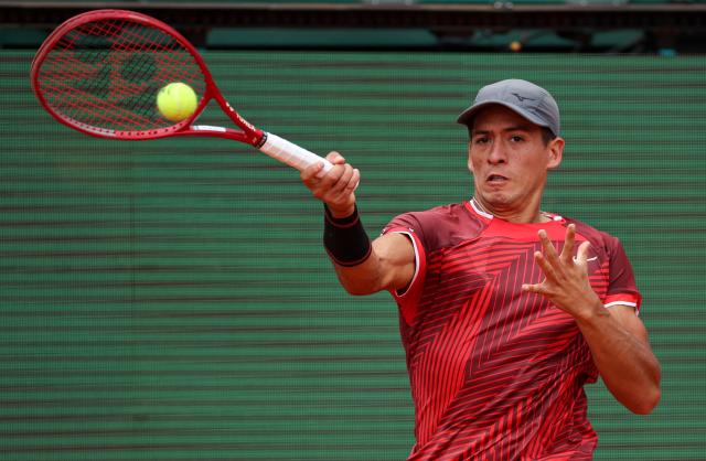 Argentina's Sebastian Baez plays a backhand return to Spain's Carlos Alcaraz during the Monte Carlo ATP Masters Series Tournament round of 64 tennis match on Court Rainier III at the Monte-Carlo Country Club in Roquebrune-Cap-Martin, south-eastern France on April 7, 2026. (Photo by Valery HACHE / AFP)