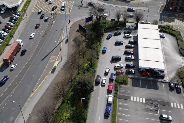An aerial view shows vehicles queuing for fuel at a branch of retail warehouse "Costco" in Liverpool, north west England on April 7, 2026. The war in the Middle East, now in its second month, has caused a record monthly rise in petrol and diesel prices in the United Kingdom. (Photo by Paul ELLIS / AFP)