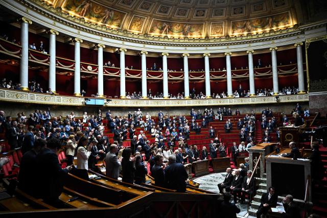 French MPs applaud as they learn that Cйcile Kohler and Jacques Paris “are free and on their way to France after three and a half years in detention in Iran” during a session of questions to the government at The National Assembly, France's lower house of parliament in Paris on April 7, 2026. (Photo by JULIEN DE ROSA / AFP)