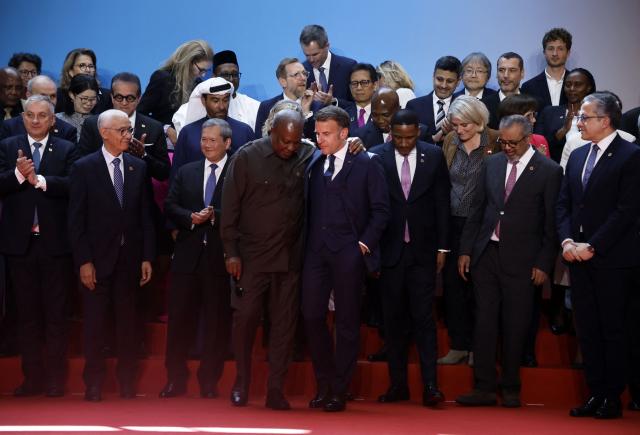 France's President Emmanuel Macron (C) speaks with Ghana’s President John Dramani Mahama (C-L) as they pose with other delegates for a family photo during the "One Health Summit" high-level meeting session in Lyon, southern France on April 7, 2026, on the occasion of World Health Day. (Photo by Christophe PETIT TESSON / POOL / AFP)
