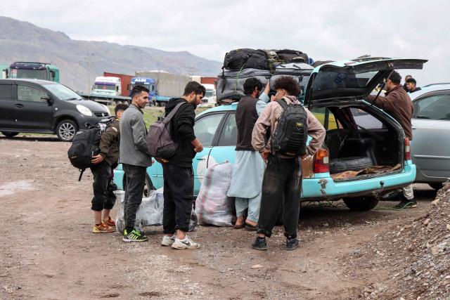Afghan migrants gather beside a vehicle as they prepare to return to their homes near the Afghanistan–Iran border in the Zendeh Jan district of Herat on April 6, 2026. In Afghanistan, which already faces a severe humanitarian crisis, rain, floods, landslides and lightning strikes killed 123 people since March 26, the spokesman of the national disaster management authority, Mohammad Yousuf Hammad, told AFP. (Photo by Mohsen KARIMI / AFP)