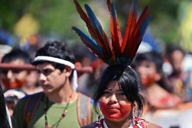 An Indigenous woman takes part in a march to the Congress building during the annual Indigenous gathering Acampamento Terra Livre (ATL) in Brasilia on April 7, 2026. Around 7,000 indigenous people from several ethnic groups take part in the week-long protest to demand land rights, justice, and equal treatment. (Photo by Evaristo Sa / AFP)