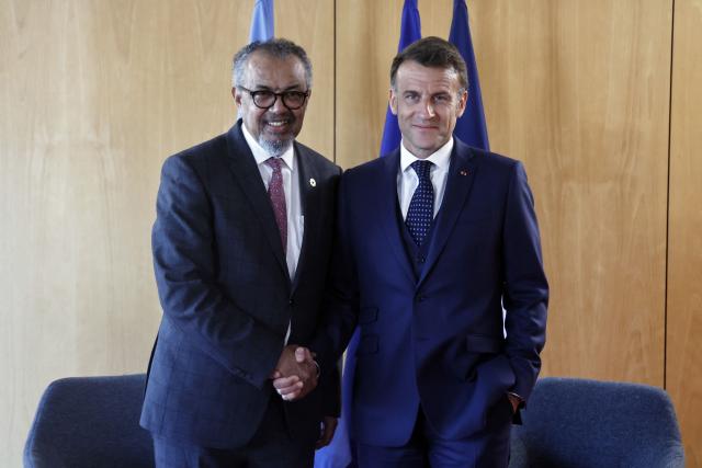 France's President Emmanuel Macron (R) shakes hands with World Health Organization (WHO) Director-General Tedros Adhanom Ghebreyesus during a meeting on the sideline of "One Health Summit" high-level meeting in Lyon, southern France on April 7, 2026. (Photo by Christophe PETIT TESSON / POOL / AFP)