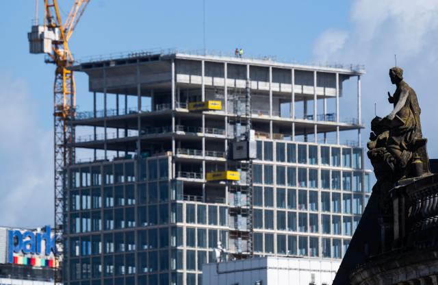 A statue overlooking the facade of the Bode museum stands in front of the 134-metre-high "MYND" tower, now called "The Berlinian", which is nearing completion, in Berlin on April 7, 2026. (Photo by John MACDOUGALL / AFP)