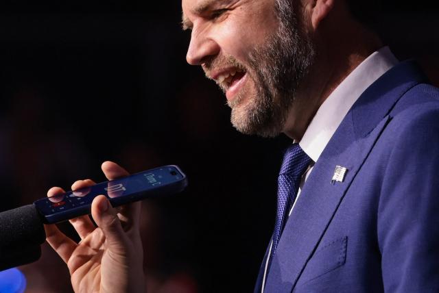 US Vice President JD Vance holds a mobile phone while on a call with US President Donald Trump to a microphone during a "Day of Friendship" event with Hungarian Prime Minister Viktor Orban (not in picture) at MTK Sportpark in Budapest, Hungary on April 7, 2026. US Vice President JD Vance is in Hungary to deliver the US President's support to his ally, nationalist Prime Minister Viktor Orban, ahead of tightly contested parliamentary elections scheduled for April 12, 2026. (Photo by Jonathan Ernst / POOL / AFP)