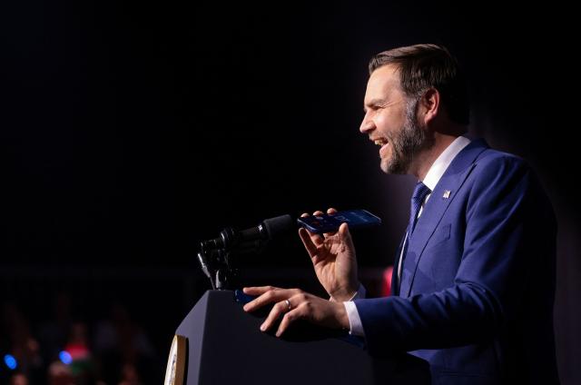 US Vice President JD Vance holds a mobile phone while on a call with US President Donald Trump to a microphone during a "Day of Friendship" event with Hungarian Prime Minister Viktor Orban (not in picture) at MTK Sportpark in Budapest, Hungary on April 7, 2026. US Vice President JD Vance is in Hungary to deliver the US President's support to his ally, nationalist Prime Minister Viktor Orban, ahead of tightly contested parliamentary elections scheduled for April 12, 2026. (Photo by Jonathan Ernst / POOL / AFP)