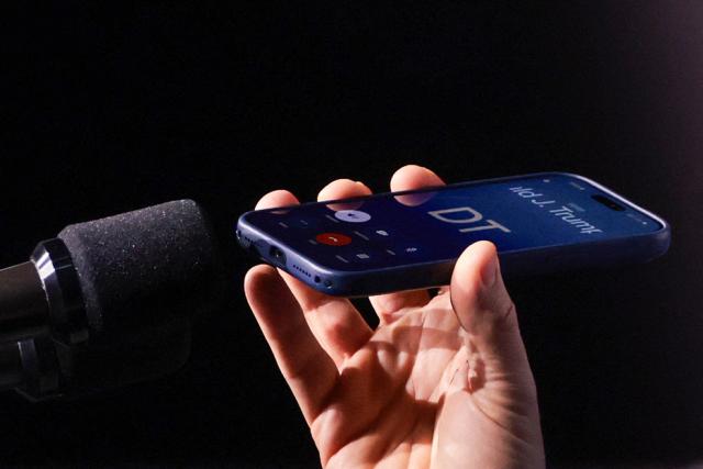 US Vice President JD Vance holds a mobile phone while on a call with US President Donald Trump to a microphone during a "Day of Friendship" event with Hungarian Prime Minister Viktor Orban (not in picture) at MTK Sportpark in Budapest, Hungary on April 7, 2026. US Vice President JD Vance is in Hungary to deliver the US President's support to his ally, nationalist Prime Minister Viktor Orban, ahead of tightly contested parliamentary elections scheduled for April 12, 2026. (Photo by Jonathan Ernst / POOL / AFP) / ALTERNATIVE CROP