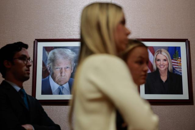 Photos of US President Donald Trump and former Attorney General Pam Bondi hang on the wall as US Acting Attorney General Todd Blanche speaks during a news conference about the Trump administration's anti-fraud efforts at the Department of Justice headquarters in Washington, DC, on April 7, 2026. (Photo by Kent Nishimura / AFP)