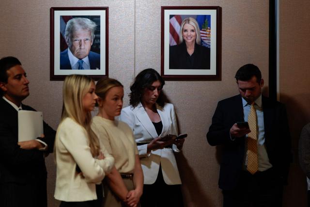 Photos of US President Donald Trump and former Attorney General Pam Bondi hang on the wall as US Acting Attorney General Todd Blanche speaks during a news conference about the Trump administration's anti-fraud efforts at the Department of Justice headquarters in Washington, DC, on April 7, 2026. (Photo by Kent Nishimura / AFP)