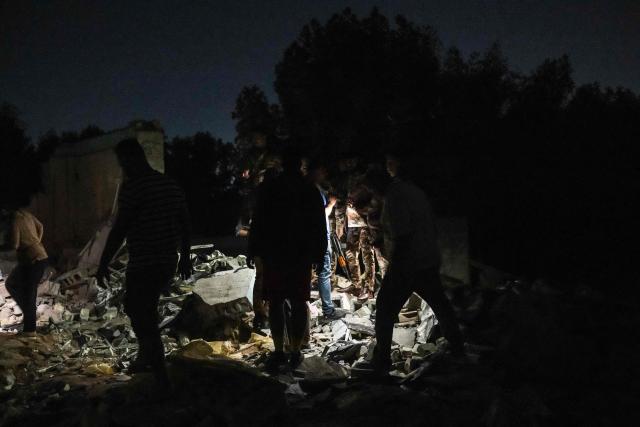 People, including members of the security forces, inspect the rubble of a house following a strike in Khor al-Zubair, in Iraq's southern province of Basra, on April 7, 2026. A strike in Iraq's southern province of Basra on April 7 killed at least three civilians, a provincial councillor and a security official told AFP. A member of Basra's provincial council said "a house in the city of Khor al-Zubair was struck by what eyewitnesses said was a jet", adding that "neighbours said the house was inhabited by five people, but until now only three bodies have been retrieved". (Photo by Hussein FALEH / AFP)