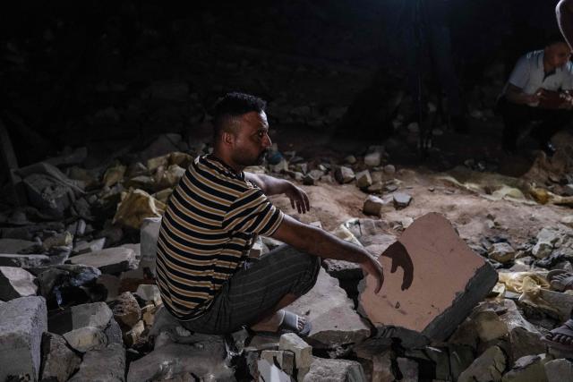 A man looks on as he sits on the rubble of a house following a strike in Khor al-Zubair, in Iraq's southern province of Basra, on April 7, 2026. A strike in Iraq's southern province of Basra on April 7 killed at least three civilians, a provincial councillor and a security official told AFP. A member of Basra's provincial council said "a house in the city of Khor al-Zubair was struck by what eyewitnesses said was a jet", adding that "neighbours said the house was inhabited by five people, but until now only three bodies have been retrieved". (Photo by Hussein FALEH / AFP)