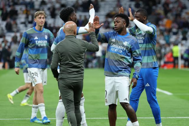Real Madrid's Brazilian forward #07 Vinicius Junior (2R) slaps hands with teammates before the UEFA Champions League quarter final first leg football match between Real Madrid CF and FC Bayern Munich at Santiago Bernabeu Stadium in Madrid on April 7, 2026. (Photo by Thomas COEX / AFP)