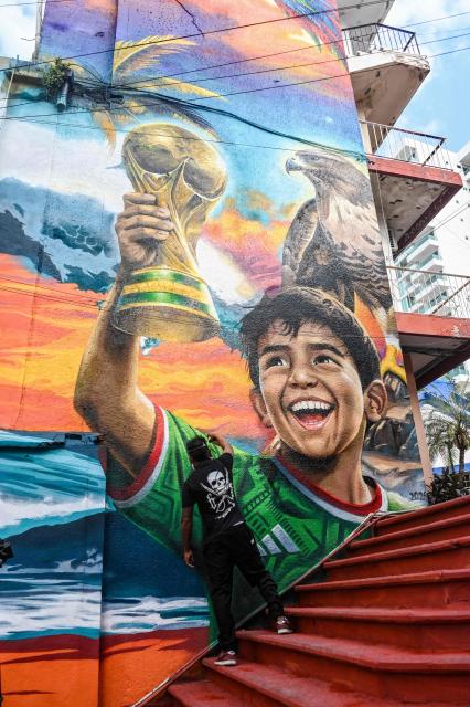 Mexican artist Ivan Bailon Hernandez works on a mural titled "Sueno Mundialista" (World Cup dream), referring to the upcoming FIFA World Cup 2026, in Acapulco, Guerrero state, Mexico, on April 7, 2026. (Photo by Faustine FRANCISCO / AFP)
