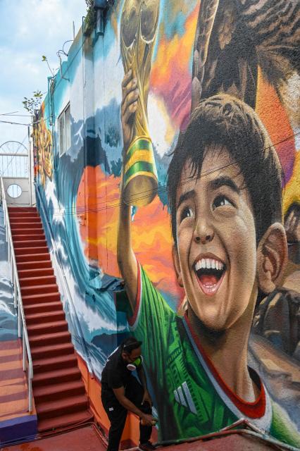 Mexican artist Ivan Bailon Hernandez works on a mural titled "Sueno Mundialista" (World Cup dream), referring to the upcoming FIFA World Cup 2026, in Acapulco, Guerrero state, Mexico, on April 7, 2026. (Photo by Faustine FRANCISCO / AFP)