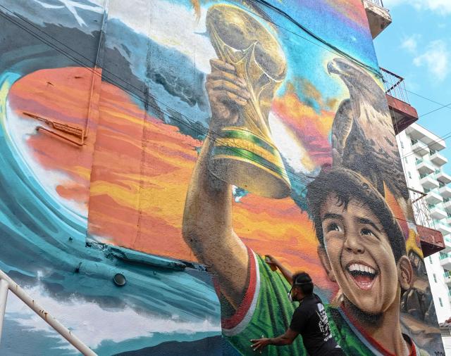 Mexican artist Ivan Bailon Hernandez works on a mural titled "Sueno Mundialista" (World Cup dream), referring to the upcoming FIFA World Cup 2026, in Acapulco, Guerrero state, Mexico, on April 7, 2026. (Photo by Faustine FRANCISCO / AFP)