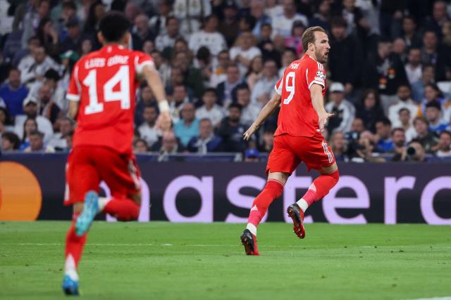 Bayern Munich's English forward #09 Harry Kane (R) celebrates scoring his team's second goal during the UEFA Champions League quarter final first leg football match between Real Madrid CF and FC Bayern Munich at Santiago Bernabeu Stadium in Madrid on April 7, 2026. (Photo by Pierre-Philippe MARCOU / AFP)