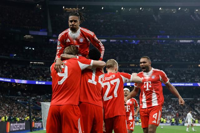 Bayern Munich players celebrate their second goal scored by Bayern Munich's English forward #09 Harry Kane (L) during the UEFA Champions League quarter final first leg football match between Real Madrid CF and FC Bayern Munich at Santiago Bernabeu Stadium in Madrid on April 7, 2026. (Photo by Oscar DEL POZO / AFP)