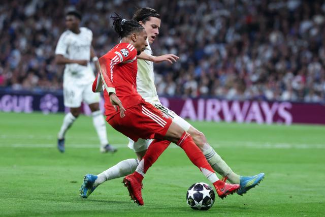 Bayern Munich's French midfielder #17 Michael Olise (L) vies for the ball with Real Madrid's Spanish defender #18 Alvaro Carreras during the UEFA Champions League quarter final first leg football match between Real Madrid CF and FC Bayern Munich at Santiago Bernabeu Stadium in Madrid on April 7, 2026. (Photo by Pierre-Philippe MARCOU / AFP)
