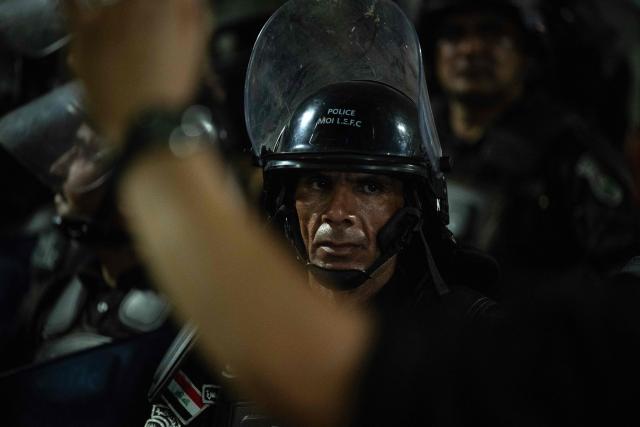 Iraqi police gather during a rally outside the Kuwaiti Consulate during a protest following a strike that killed three people in a nearby town, in the southern Iraqi city of Basra on April 7, 2026. A strike in Iraq's southern province of Basra on April 7, killed at least three civilians, a provincial councillor and a security official told AFP. A member of Basra's provincial council, said "a house in the city of Khor al-Zubair was struck by what eyewitnesses said was a jet", adding that "neighbours said the house was inhabited by five people, but until now only three bodies have been retrieved". (Photo by Hussein FALEH / AFP)