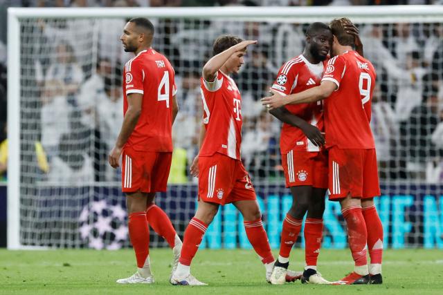 Bayern Munich's English forward #09 Harry Kane (R) and teammates celebrate their victory at the end of the UEFA Champions League quarter final first leg football match between Real Madrid CF and FC Bayern Munich at Santiago Bernabeu Stadium in Madrid on April 7, 2026. (Photo by Oscar DEL POZO / AFP)