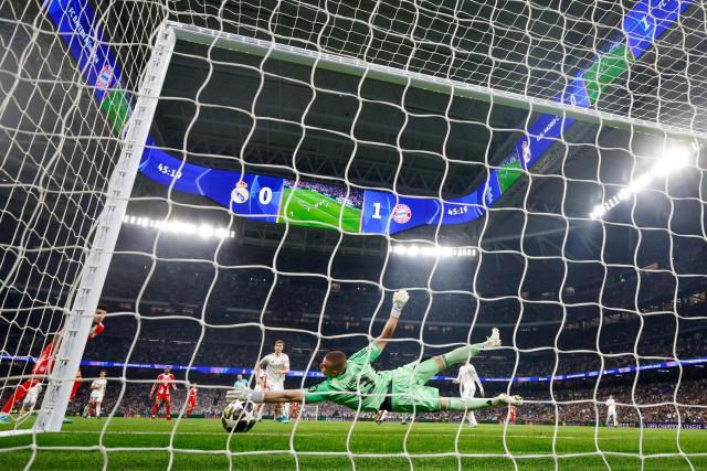 Real Madrid's Ukrainian goalkeeper #13 Andriy Lunin fails to stop the 0-2 goal by Bayern Munich's English forward #09 Harry Kane (out of frame) during the UEFA Champions League quarter final first leg football match between Real Madrid CF and FC Bayern Munich at Santiago Bernabeu Stadium in Madrid on April 7, 2026. (Photo by Pierre-Philippe MARCOU / AFP)