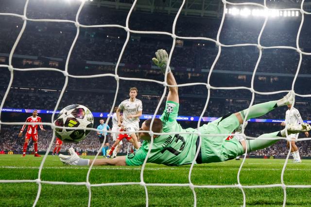 Real Madrid's Ukrainian goalkeeper #13 Andriy Lunin fails to stop the 0-2 goal by Bayern Munich's English forward #09 Harry Kane (out of frame) during the UEFA Champions League quarter final first leg football match between Real Madrid CF and FC Bayern Munich at Santiago Bernabeu Stadium in Madrid on April 7, 2026. (Photo by Pierre-Philippe MARCOU / AFP)