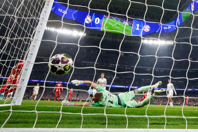 Real Madrid's Ukrainian goalkeeper #13 Andriy Lunin fails to stop the 0-2 goal by Bayern Munich's English forward #09 Harry Kane (out of frame) during the UEFA Champions League quarter final first leg football match between Real Madrid CF and FC Bayern Munich at Santiago Bernabeu Stadium in Madrid on April 7, 2026. (Photo by Pierre-Philippe MARCOU / AFP)