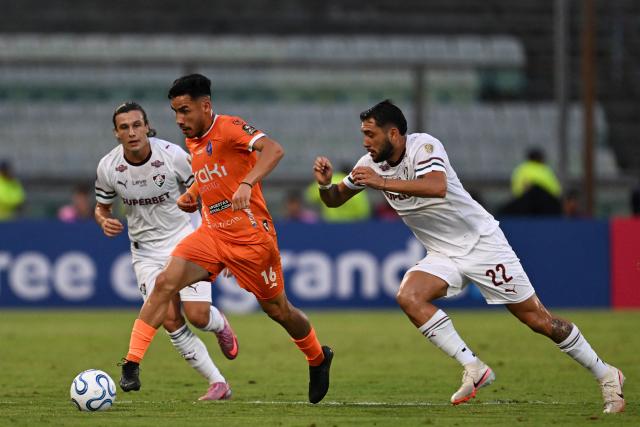 Deportivo La Guaira's defender #16 Luis Pena and Fluminense's Argentine defender #22 Juan Pablo Freytes fight for the ball during the Copa Libertadores group stage football match between Venezuela's Deportivo La Guaira and Brazil's Fluminense at the Olimpico de la UCV stadium in Caracas on April 7, 2026. (Photo by Juan BARRETO / AFP)