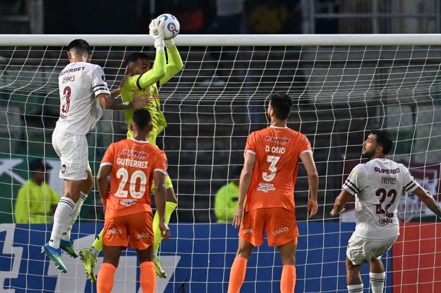 Deportivo La Guaira's goalkeeper #01 Christopher Varela jumps to grab the ball over Fluminense's defender #03 Jemmesduring the Copa Libertadores group stage football match between Venezuela's Deportivo La Guaira and Brazil's Fluminense at the Olimpico de la UCV stadium in Caracas on April 7, 2026. (Photo by Juan BARRETO / AFP)