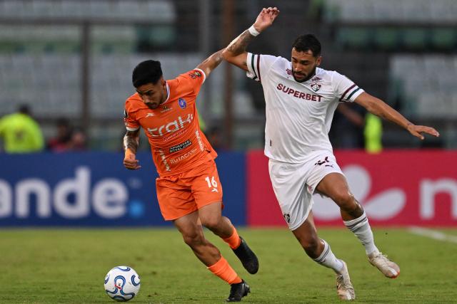 Deportivo La Guaira's defender #16 Luis Pena and Fluminense's Argentine defender #22 Juan Pablo Freytes fight for the ball during the Copa Libertadores group stage football match between Venezuela's Deportivo La Guaira and Brazil's Fluminense at the Olimpico de la UCV stadium in Caracas on April 7, 2026. (Photo by Juan BARRETO / AFP)