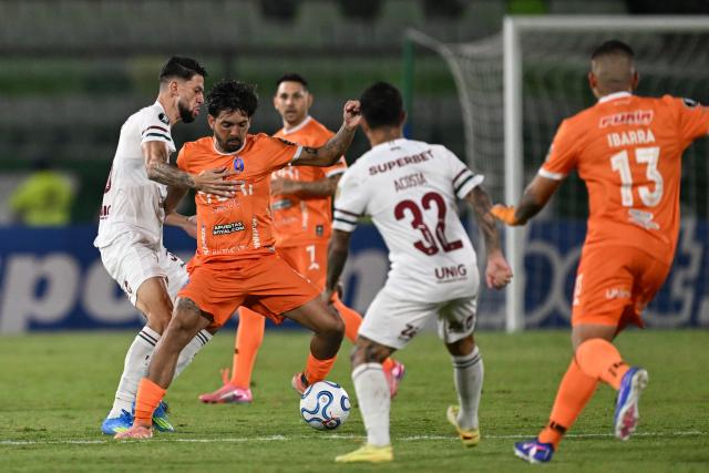 Deportivo La Guaira's midfielder #08 Juan Perdomo fights for the ball with Fluminense's Argentine midfielder #32 Luciano Acosta and Fluminense's defender #03 Jemmes during the Copa Libertadores group stage football match between Venezuela's Deportivo La Guaira and Brazil's Fluminense at the Olimpico de la UCV stadium in Caracas on April 7, 2026. (Photo by Juan BARRETO / AFP)