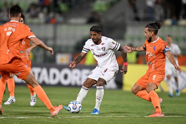 Fluminense's forward #09 John Kennedy fights for the ball with Deportivo La Guaira's defender #04 Carlos Rivero and Deportivo La Guaira's forward #07 Jose Ali Meza during the Copa Libertadores group stage football match between Venezuela's Deportivo La Guaira and Brazil's Fluminense at the Olimpico de la UCV stadium in Caracas on April 7, 2026. (Photo by Juan BARRETO / AFP)