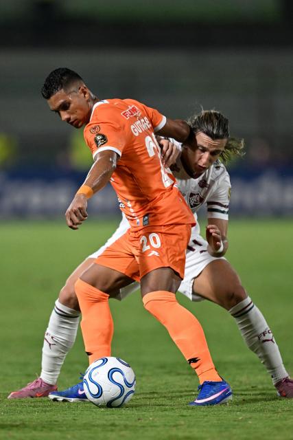 Deportivo La Guaira's Panamanian defender #20 Jorge Gutierrez and Fluminense's Uruguayan midfielder #17 Agustin Canobbio fight for the ball during the Copa Libertadores group stage football match between Venezuela's Deportivo La Guaira and Brazil's Fluminense at the Olimpico de la UCV stadium in Caracas on April 7, 2026. (Photo by Juan BARRETO / AFP)
