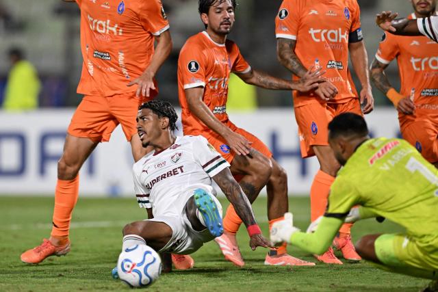 Fluminense's forward #09 John Kennedy and Deportivo La Guaira's goalkeeper #01 Christopher Varela during the Copa Libertadores group stage football match between Venezuela's Deportivo La Guaira and Brazil's Fluminense at the Olimpico de la UCV stadium in Caracas on April 7, 2026. (Photo by Juan BARRETO / AFP)