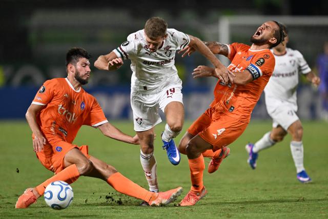 Fluminense's Uruguayan forward #19 Castillo fights for the ball with Deportivo La Guaira's defender #03 Diego Osio and Deportivo La Guaira's defender #04 Carlos Rivero during the Copa Libertadores group stage football match between Venezuela's Deportivo La Guaira and Brazil's Fluminense at the Olimpico de la UCV stadium in Caracas on April 7, 2026. (Photo by Juan BARRETO / AFP)