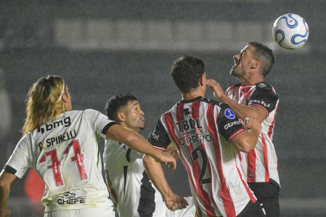 Barracas Central's midfielder #05 Dardo Miloc (R) heads the ball against Vasco da Gama's Argentinian forward #77 Claudio Spinelli and Barracas Central's defender #02 Nicolas Capraro during the Copa Sudamericana group stage football match between Argentina's Barracas Central and Brazil's Vasco da Gama at the Florencio Sola stadium in Banfield, Buenos Aires province, Argentina, on April 7, 2026. (Photo by JUAN MABROMATA / AFP)