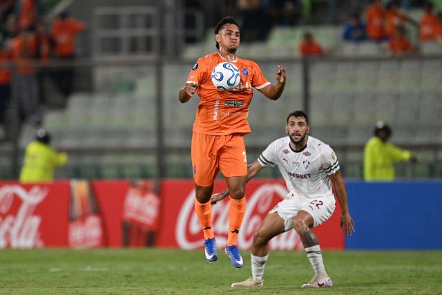Deportivo La Guaira's forward #25 Junior Paredes attempts to control the ball over Fluminense's Argentine defender #22 Juan Pablo Freytes during the Copa Libertadores group stage football match between Venezuela's Deportivo La Guaira and Brazil's Fluminense at the Olimpico de la UCV stadium in Caracas on April 7, 2026. (Photo by Juan BARRETO / AFP)