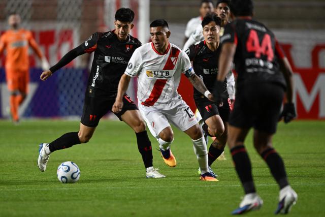 Always Ready's defender Hector Cuellar fights for the ball with Liga de Quito's Bolivian midfielder #15 Gabriel Villamil and Liga de Quito's Peruvian midfielder #8 Jesus Pretell during the Copa Libertadores group stage football match between Bolivia's Always Ready and Ecuador's Liga de Quito at the Municipal de Villa Ingenio stadium in El Alto, La Paz department, Bolivia, on April 7, 2026. (Photo by AIZAR RALDES / AFP)